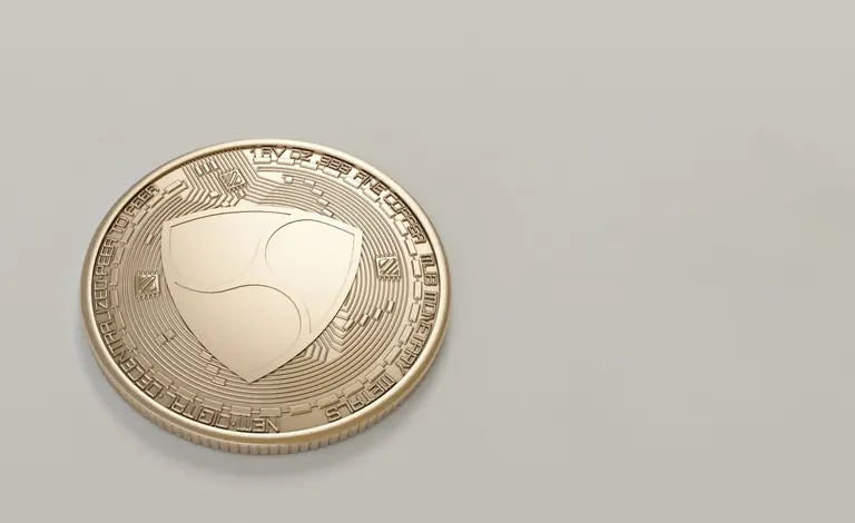 Close-up of a golden NEM cryptocurrency coin on a neutral background.